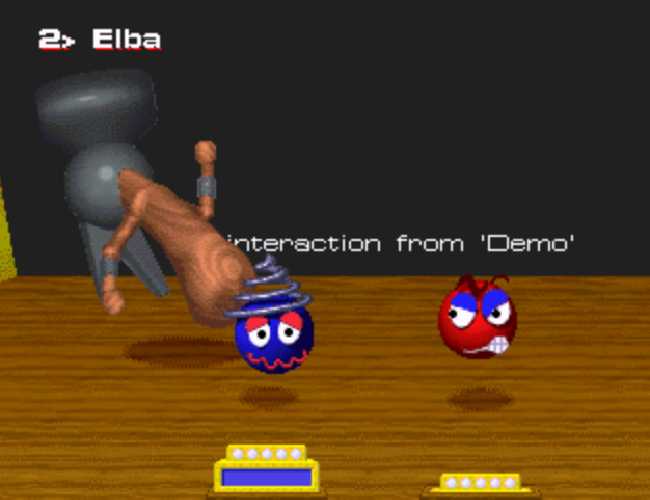Two floating heads on a wooden stage consisting of colored spheres with shapes suggesting facial features. The blue head on the left with a red squiggly grin is about to be smashed by a large floating hammer with arms which is rearing back behind it about to slam down. The red head on the right stares at the ill-fated blue head with a toothy smirk. Behind all of them is a screen with text that reads "No interaction from Demo" because I took this screen shot with the module in demo mode.